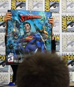 Panelist Scheller holds up a Superman swag bag distributed by Comic-Con