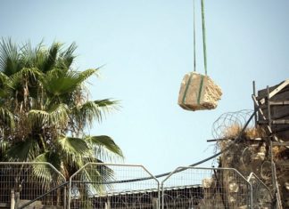 Antiquities Authority experts to determine fate of dislodged rock from Western Wall Workers remove by crane a large chunk of stone dislodged from the Western Wall in Jerusalem's Old City at the mixed-gender prayer section on July 25, 2018. Photo by Hadas Parush/Flash90.