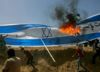Shin Bet head tells Knesset committee it prevented 1,000-plus terror attacks this year Palestinians protestors burn a a giant Israeli flag during clashes with Israeli security forces on the Gaza Israeli border east of Khan Yunis, in the southern Gaza Strip on April 6, 2018. Photo by Abed Rahim Khatib/Flash90.