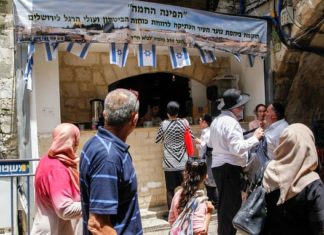 PA releases Palestinian American sentenced to life for selling land to Jews Muslims walk near a shop belongs to Israelis during Ramadan in the Muslim Quarter of Jerusalem's Old City on May 20, 2018. Photo by Sliman Khader/Flash90.