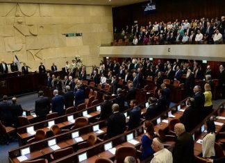 Knesset approves first reading of bill to dissolve government Israeli lawmakers stand during the inauguration of the 21st Knesset. Photo: Haim Zach/GPO.