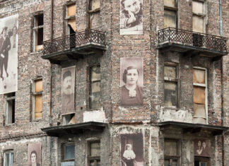 New monument pays tribute to archive hidden by Jews in Warsaw Ghetto A building from the Warsaw Ghetto with pictures of Jews on the facade. Credit: Anastasia Petrova/Shutterstock.