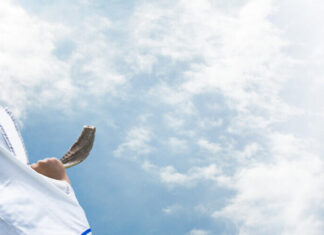 The ‘fast’ track to inspiration: 10 tips for a transformative Yom Kippur Jewish man in Tallit blowing the Shofar. Credit: MIA Studio/Shutterstock.