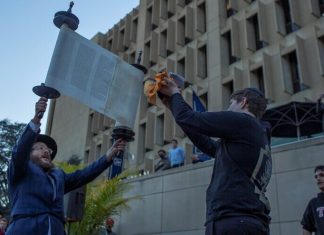 Hundreds march at George Washington University to take stand against anti-Semitism Rabbi Yudi Steiner, director of the Rohr Chabad at GW, holds up a Torah at a campus rally against anti-Semitism on Nov. 2, 2021. Credit: @phebegphoto/The Rohr Chabad at GW.