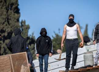 EU tries to twist international law to fight eviction of Sheikh Jarrah squatters in Jerusalem Palestinians with gas cylinders stand on a rooftop of a house being evacuated by Israeli special forces, in the eastern Jerusalem neighborhood of Sheikh Jarrah, on Jan. 17, 2022. Photo by Yonatan Sindel/Flash90.