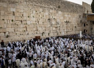 60,000 tourists to visit Israel during Passover and Easter Jews cover themselves with prayer shawls at the Western Wall in Jerusalem during the Priestly Blessing for Passover, April 18, 2022. Photo by Yonatan Sindel/Flash90.