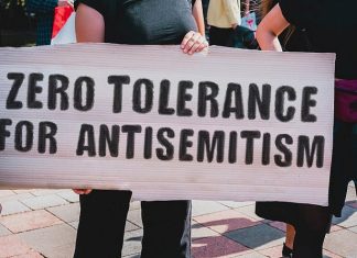 Antisemitism is alive and well in the United States A woman holds a sign opposing antisemitism at a rally. Credit: AndriiKoval/Shutterstock.