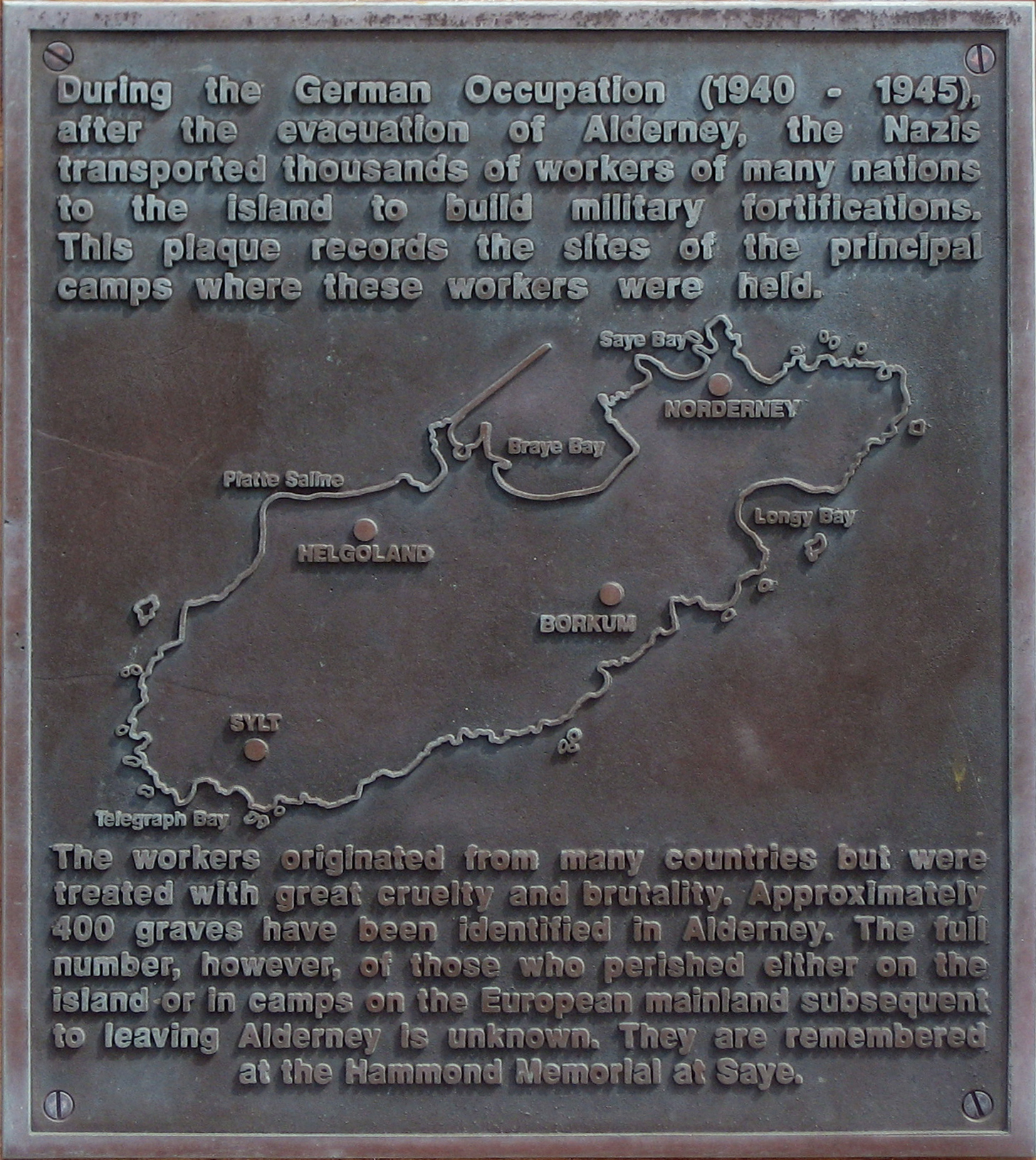 During the German Occupation (1940-1945), after the evacuation of Alderney, the Nazis transported thousands of workers from many nations to the island of Alderney to build military fortifications. This plaque records the sites of the principal camps where these workers were held. Credit: Andree Stephan via Wikimedia Commons.