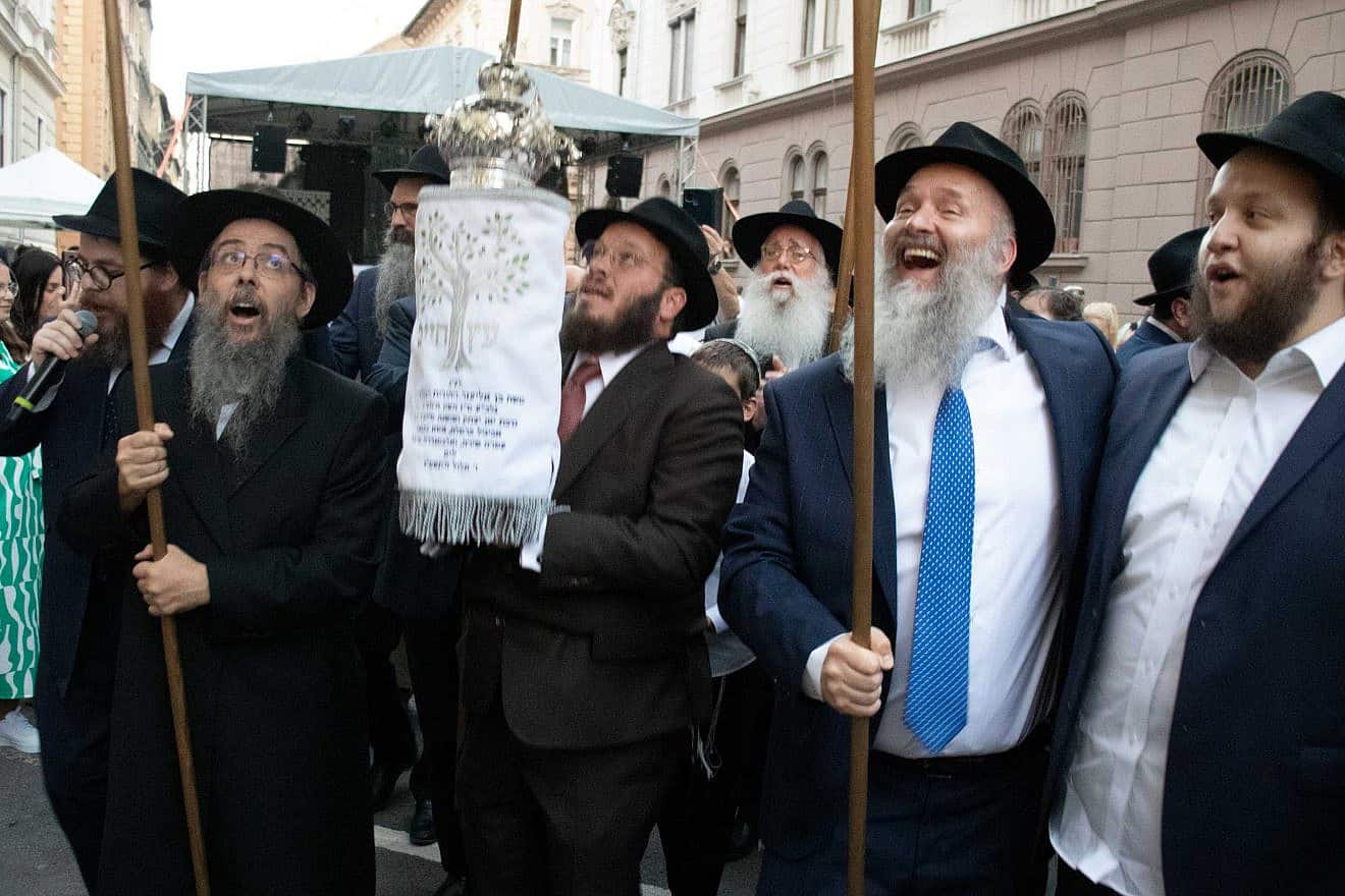 Gábor Keszler, president of MAOIH, (second from right) accompanies the Torah scroll to the reopened synagogue. Photo by David Isaac.