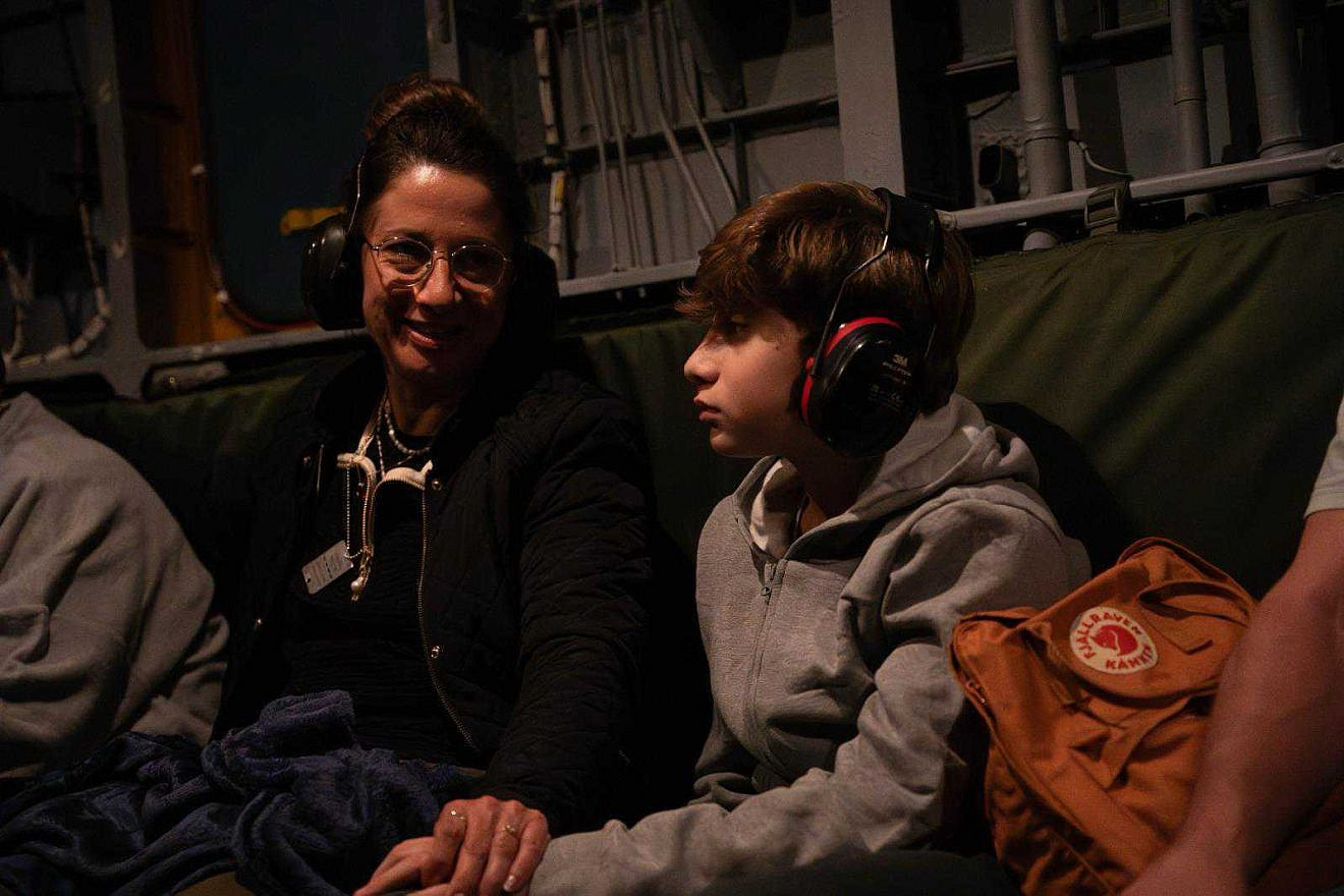 Yagil Yaakov, 13, holds his mother’s hand on an IDF helicopter after being released from Hamas captivity on Nov. 27, 2023. Credit: Israel Defense Forces.