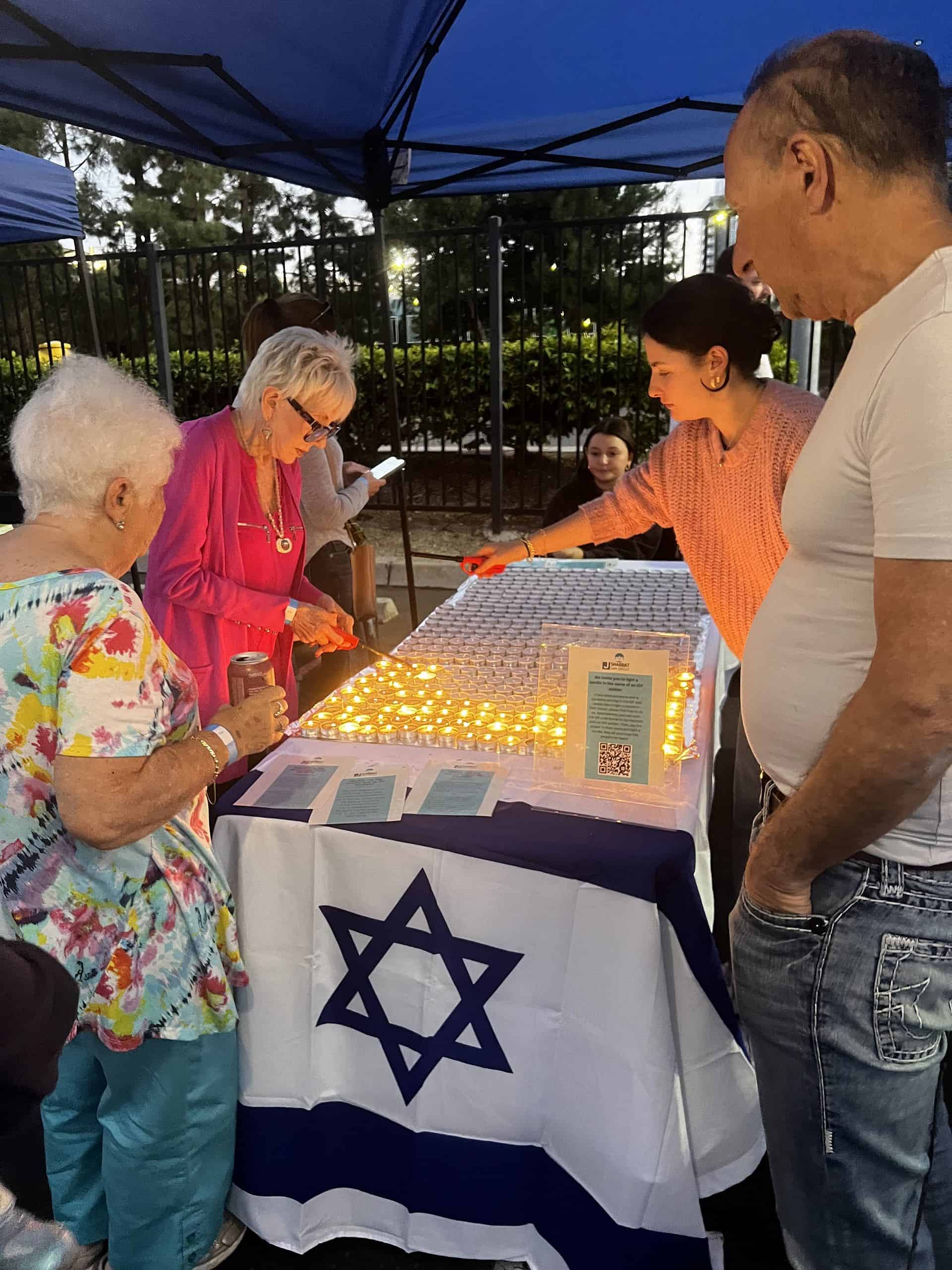 Women light candles before the start of Shabbat for those killed during the Oct. 7 terrorist attacks in southern Israel at a Shabbat marketplace in San Diego on Nov. 3, 2023. Credit: Courtesy.