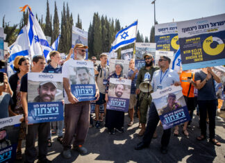 Bereaved Israeli families ask police to prosecute former judge who tore down photos of hostages, fallen soldiers