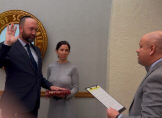 Orthodox Jewish Arizona council member uses family Bible for swearing-in ceremony Adam Kwasman is sworn in as a member of the Scottsdale City Council in Arizona on his family’s copy of a Hebrew Bible published by the late renowned Rabbi Adin Steinsaltz, as his wife Orit Kwasman looks on, Dec. 9, 2024. Credit: Courtesy of Adam Kwasman.