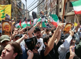 Hezbollah holds fire after US strikes Iranian nuclear sites Hezbollah supporters wave PLO and Iranian flags as they demonstrate in support of Iran, after Friday noon prayers in Beirut's southern suburbs, on June 20, 2025. Photo by Anwar Amro/AFP via Getty Images.