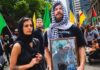 Israel deports foreign activist who supports Hamas An activist poses with a portrait of Hamas terrorist leader Yahya Sinwar during an anti-Israel protest in Melbourne, Australia. Credit: Israel Police.