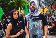 Israel deports foreign activist who supports Hamas An activist poses with a portrait of Hamas terrorist leader Yahya Sinwar during an anti-Israel protest in Melbourne, Australia. Credit: Israel Police.